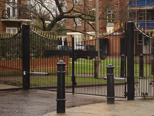 These gates open automatically with a multi user remote control.  They are wrought iron double gates with gold painted decorations to finish.