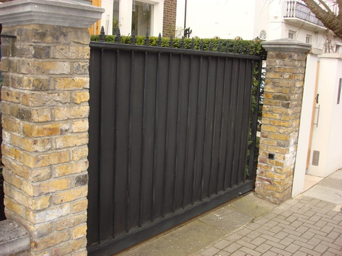 Another sheeted wrought iron gate with metal sheeting for security and privacy, and decorations on the top